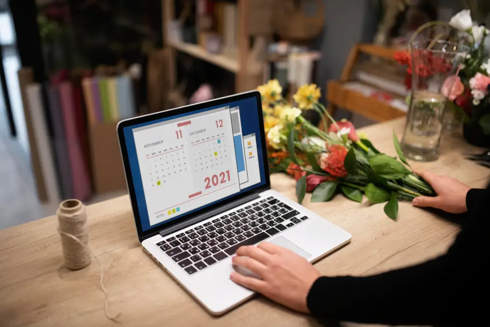 Female florist using a laptop to manage her UK Shopify store
