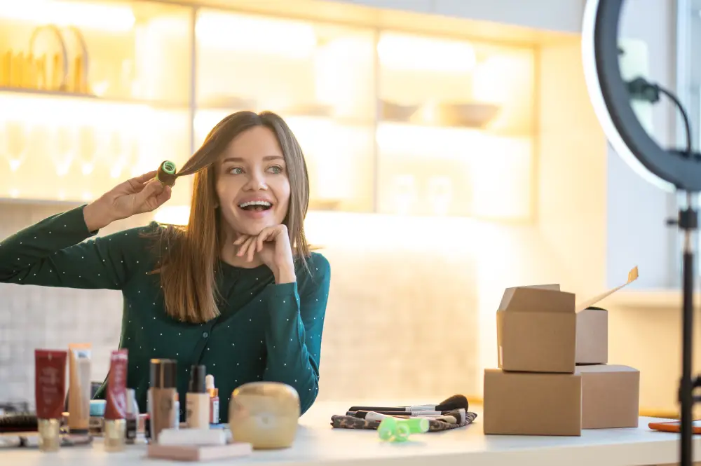 Smiling young woman demonstrating a hair styling product
