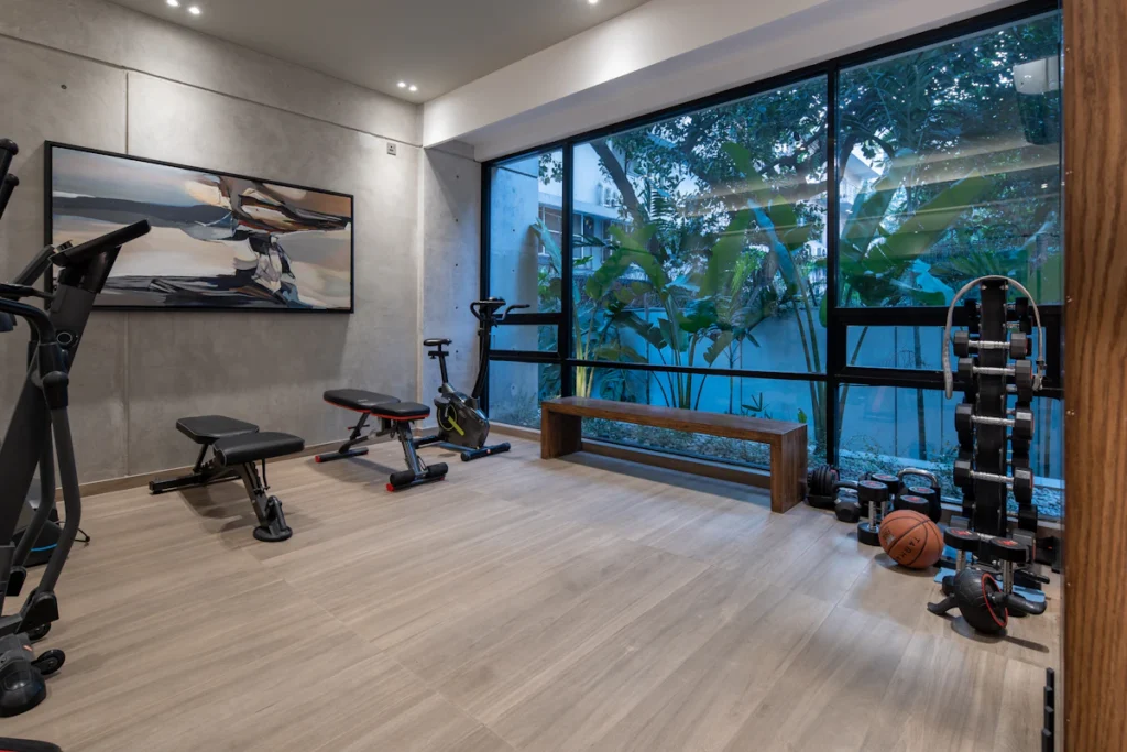 Home gym with fitness equipment, bench and weights